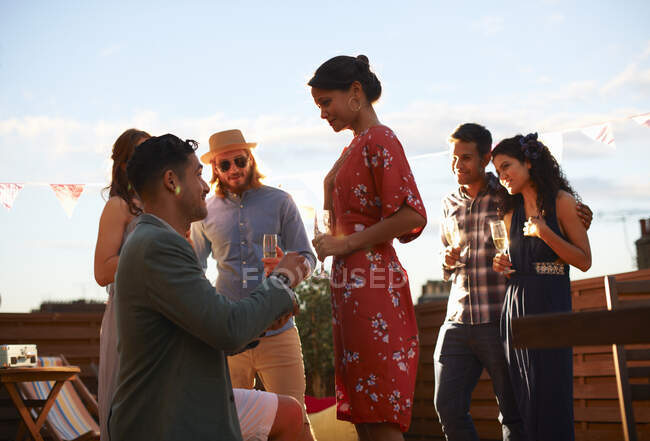 Homem propondo a mulher no terraço, pôr do sol no fundo — Fotografia de Stock