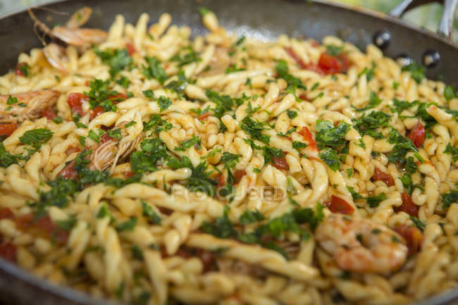 Pan of pasta with tomatoes and prawns — Stock Photo