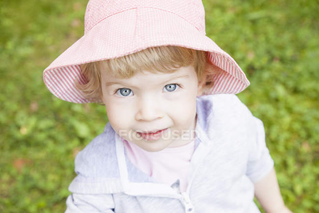 Portrait of female toddler wearing pink sunhat — Stock Photo