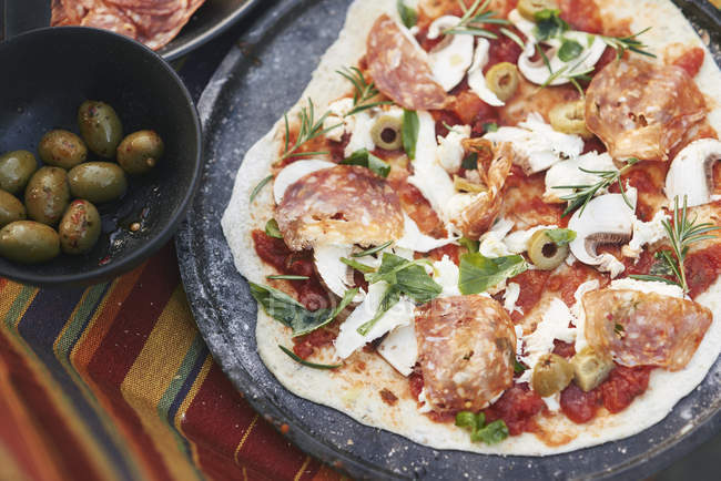 Pizza fatta in casa cruda sul tavolo da giardino — Foto stock