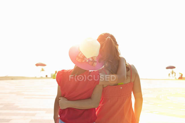 Вид сзади на женщину и дочь, стоящих на пляже — стоковое фото