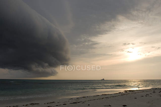 Nubes de tormenta formándose sobre el mar con barco - foto de stock