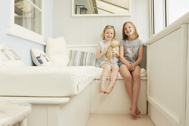 Retrato de duas irmãs sentadas no alpendre do apartamento de férias — Fotografia de Stock