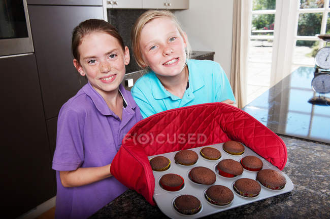 Meninas com bandeja de bolos cozidos frescos — Fotografia de Stock