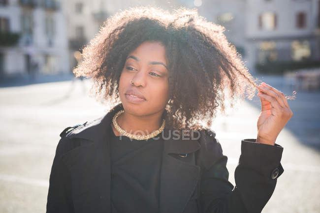 Retrato de jovem mulher olhando para longe na praça da cidade — Fotografia de Stock