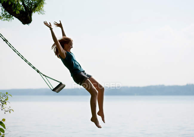 Menina pulando do balanço — Fotografia de Stock