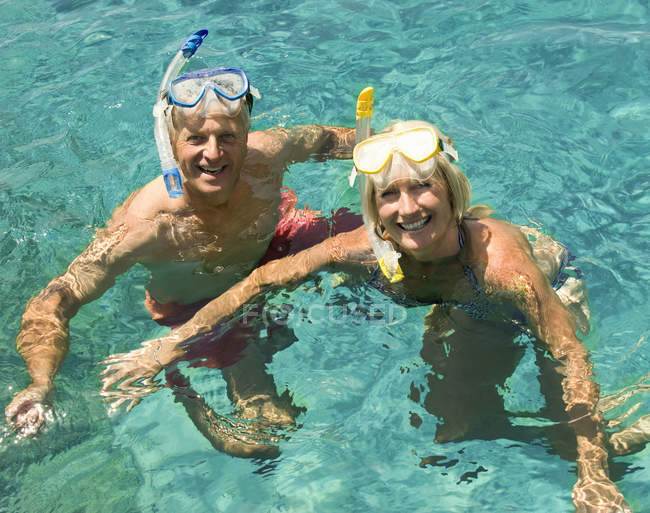 Casal maduro nadando com snorkels — Fotografia de Stock