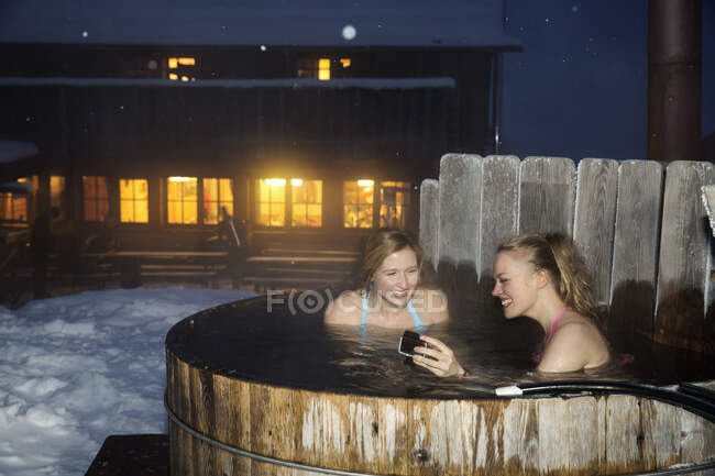 Mujeres jóvenes disfrutando de bañera de hidromasaje - foto de stock