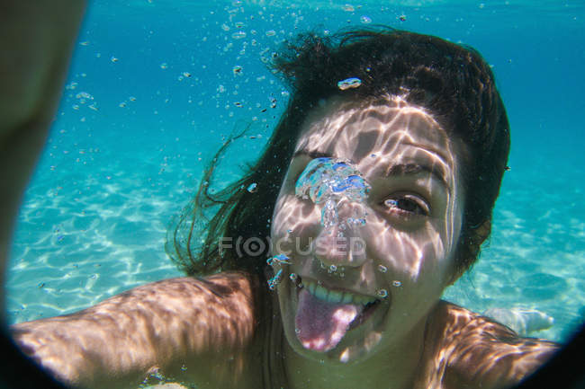 Giovane donna che nuota sott'acqua nell'oceano — Foto stock