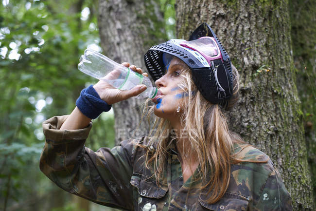 Paintball player drinking from bottle — Stock Photo