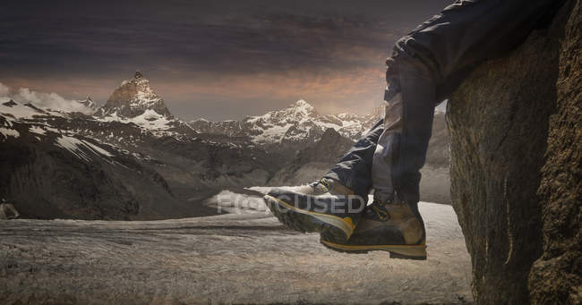 Male feet dangling over rock edge, Canton Wallis, Switzerland — Stock Photo