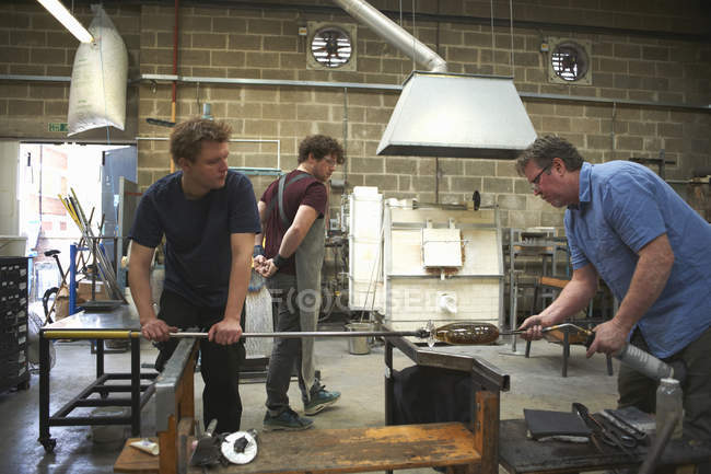 Male caucasian Glassblowers in workshop using blowtorch — Stock Photo