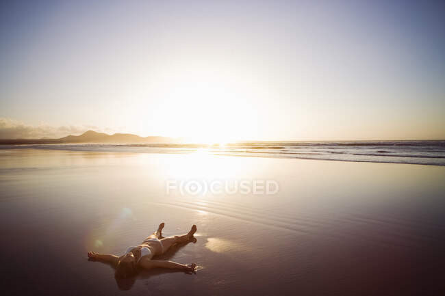 Frau liegt am Strand, Lanzarote, Kanarische Inseln, Spanien — Stockfoto
