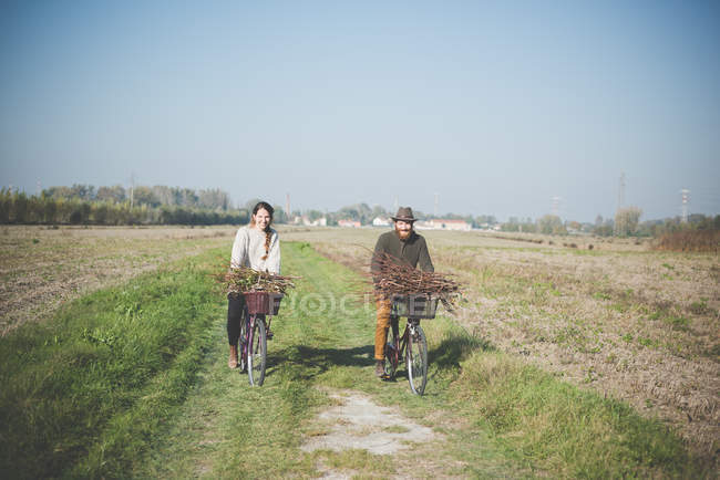 Pareja joven ciclismo en el campo, Dolo, Venecia, Italia - foto de stock