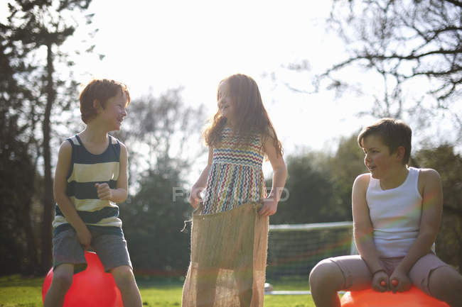 Young children on inflatable hopper and standing in sack, ready for race — Stock Photo