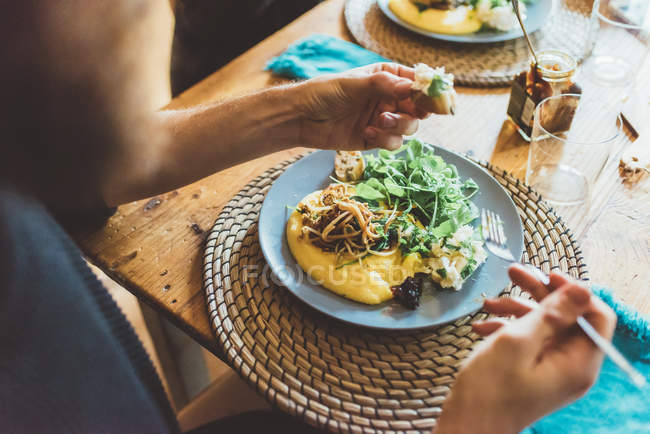 Sobre a vista do ombro do homem comendo omelete almoço à mesa — Fotografia de Stock