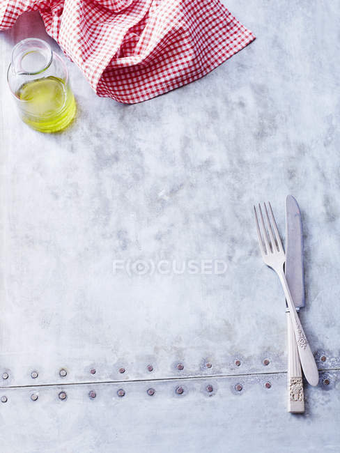 Huile d'olive, serviette et couverts sur la surface métallique — Photo de stock