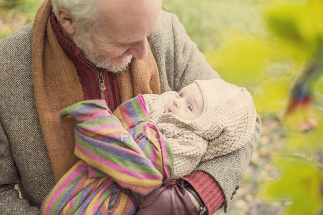 Grandfather cradling grandson, high angle — Stock Photo