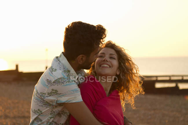 Casal jovem envolto em toalha na praia — Fotografia de Stock