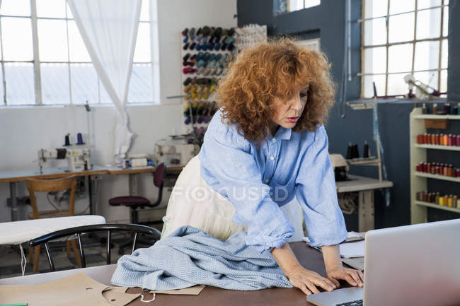 Dressmaker en atelier posant à la caméra — Photo de stock
