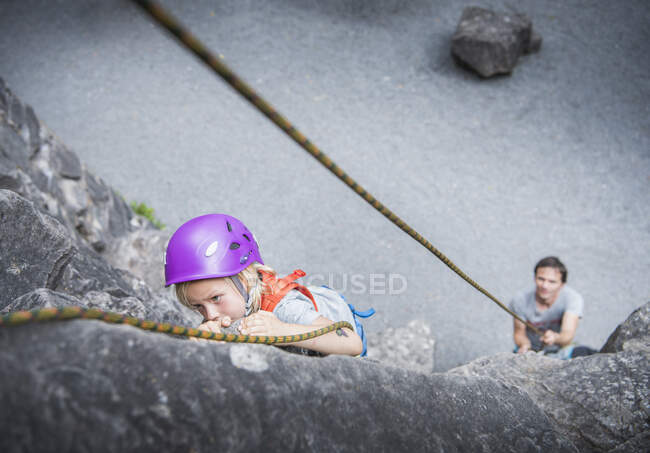 Boy wearing climbing helmet rock climbing — Stock Photo