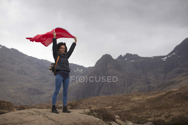 Woman holding red flag in mountains, Fairy Pools, Isle of Skye, Hebrides, Scotland — Stock Photo