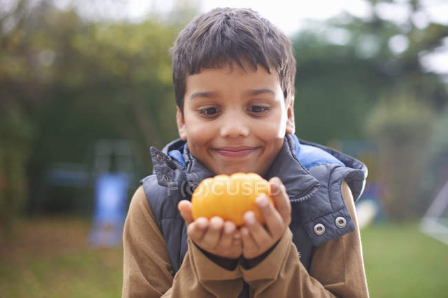 Boy with pumpkin posing in garden — Stock Photo