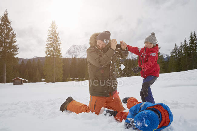 Man and sons having snowball fight in winter, Elmau, Bavaria, Germany — Stock Photo