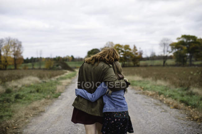 Madre e figlia che si abbracciano su strada sterrata, Lakefield, Ontario, Canada — Foto stock