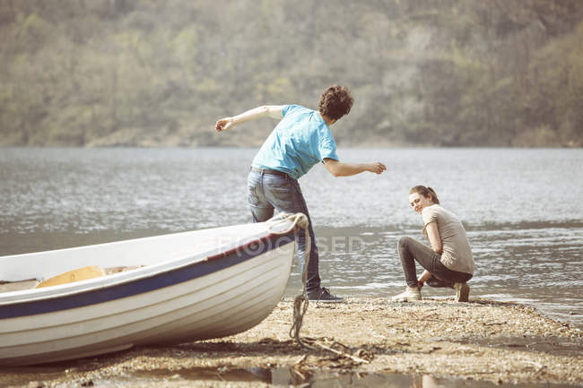 Молодий чоловік і подруга skimming камені в озеро Mergozzo Verbania,-П'ємонте, Італія — стокове фото