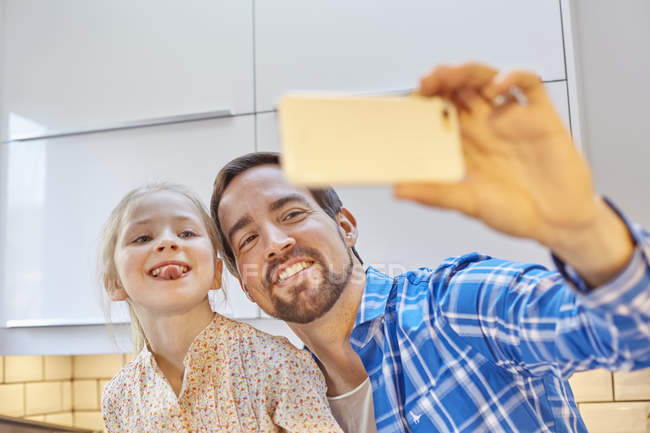 Père et fille prenant selfie dans la cuisine — Photo de stock
