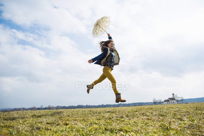 Девочка-подросток в поле с зонтиком — стоковое фото