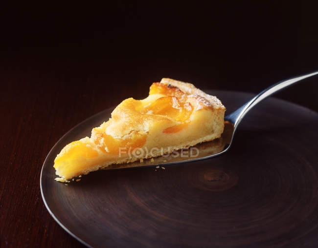 Fatia de torta de damasco com servidor de bolo na placa — Fotografia de Stock