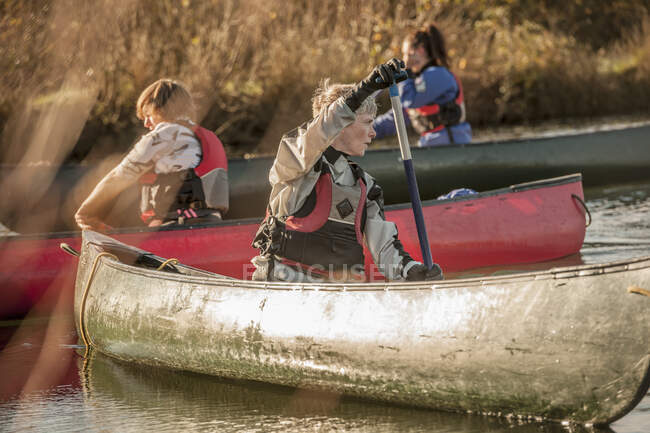 Mitte erwachsene Frau dreht sich im Kanu um — Stockfoto