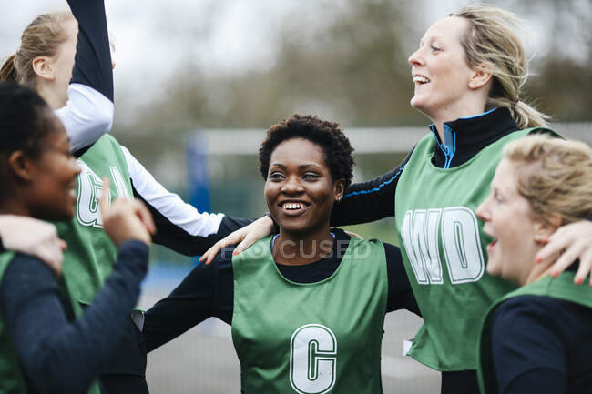 Equipo femenino de netball celebrando victoria en cancha de netball - foto de stock