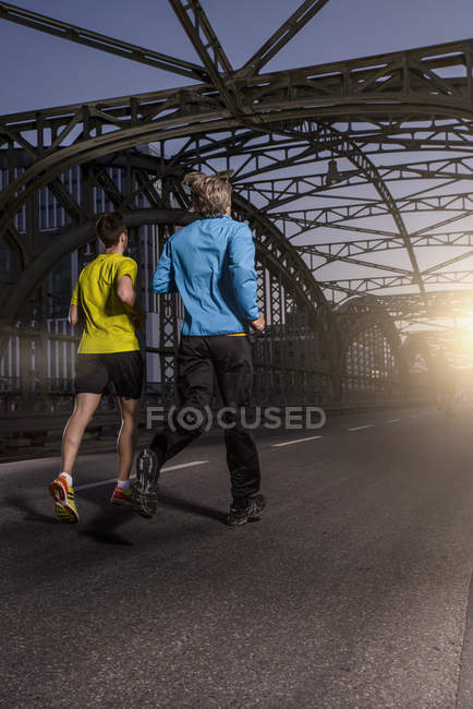Freunde joggen auf Brücke, München, Bayern, Deutschland — Stockfoto