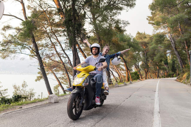 Parejas montando ciclomotor en carretera rural, Split, Dalmacia, Croacia - foto de stock