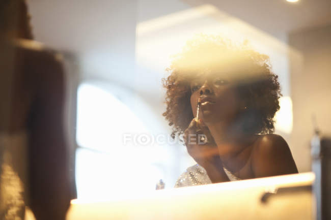Woman putting on make up — Stock Photo