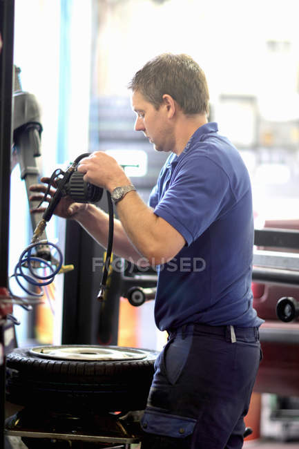 Mechanic repairing wheel in workshop — Stock Photo