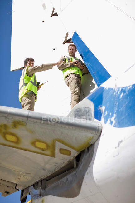 Aircraft workers repairing airplane — Stock Photo