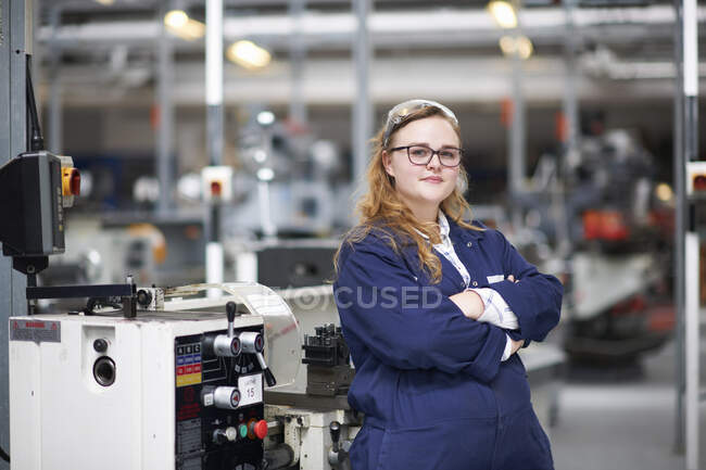 Portrait of female higher education student in machine workshop at college — Stock Photo