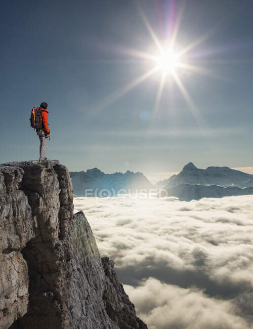 Scalatore che si affaccia dalla vetta emergente dalla nebbia nelle Alpi, Bettmeralp, Vallese, Svizzera — Foto stock