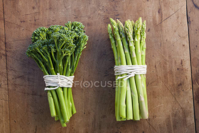 Bunches of broccoli and asparagus tied with strings — Stock Photo