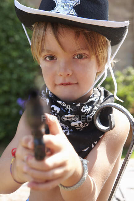 Chico en sombrero de sheriff con arma - foto de stock