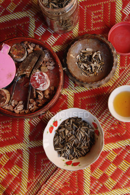 Natura morta di ciotole con semi di girasole e noci di betel — Foto stock