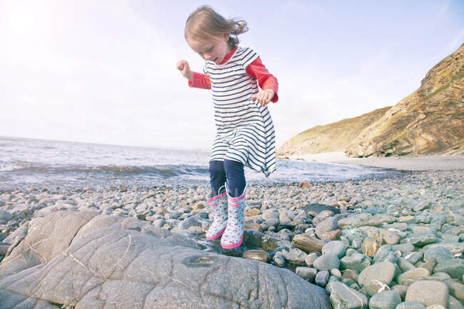 Fille marche sur les cailloux, Millook Beach, Cornouailles — Photo de stock