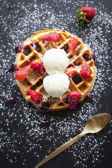Morangos e sorvete waffle na ardósia polvilhada com açúcar de confeiteiro, vista aérea — Fotografia de Stock