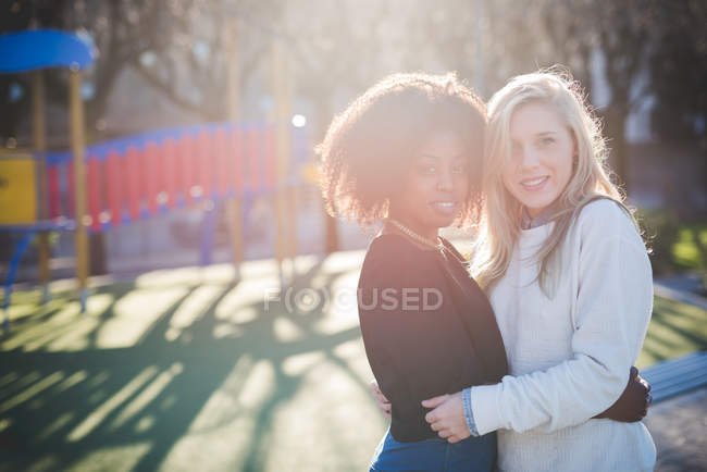 Portrait de deux amies embrassant dans le parc — Photo de stock