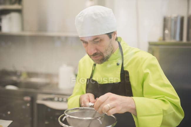 Mature boulanger masculin cuisine dans la cuisine commerciale — Photo de stock