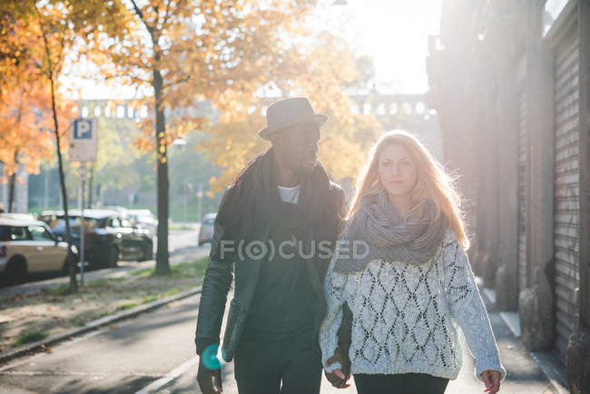 Casal andando no pavimento ao ar livre durante o dia — Fotografia de Stock